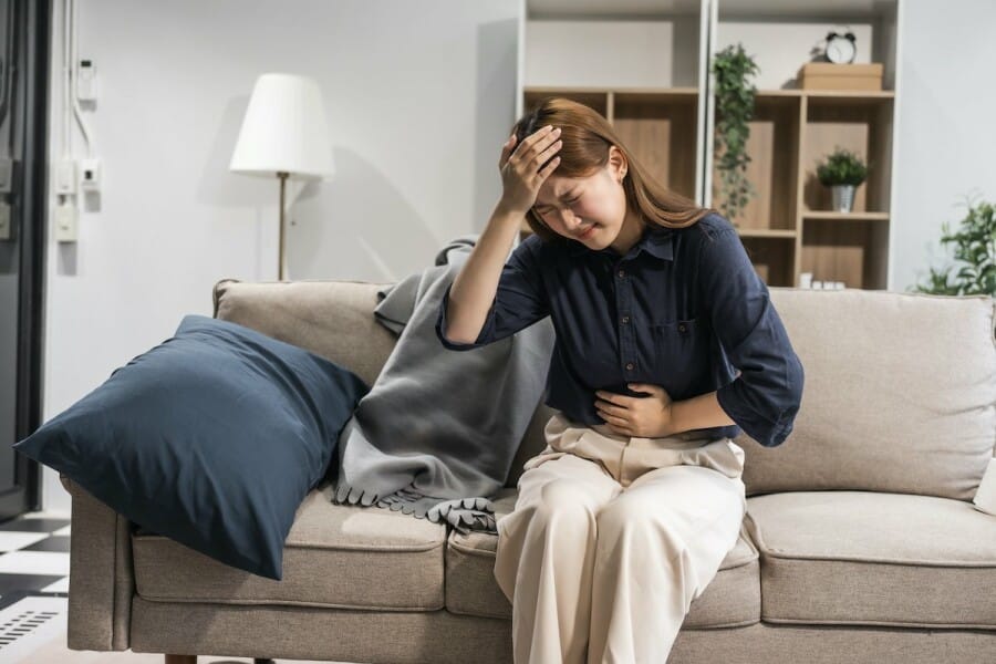 mujer con dolor a punto de tomar naproxeno o ibuprofeno